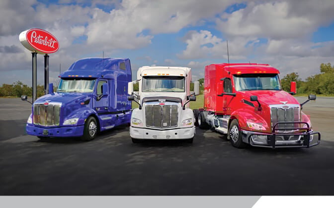 Blue White and Red Peterbilt 579 trucks lined up in a row