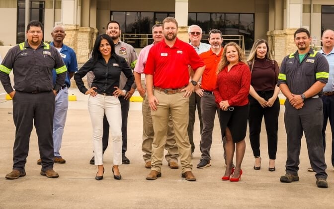 Group of dealership managers standing in front of dealerhsip
