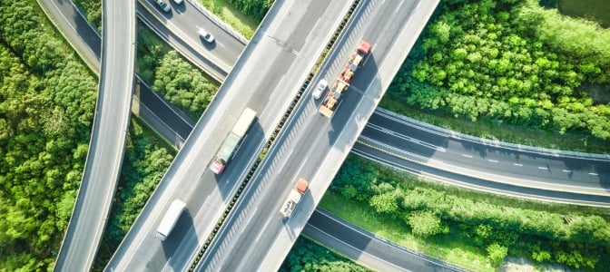 Birdseye view of highway with driving trucks