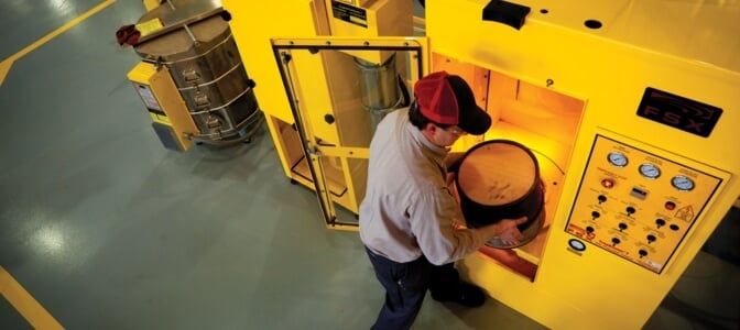 Technician putting diesel particulate filter in thermal cleaning machine