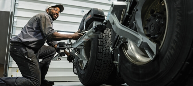 Rush Truck Centers technician using alignment tool on truck tires