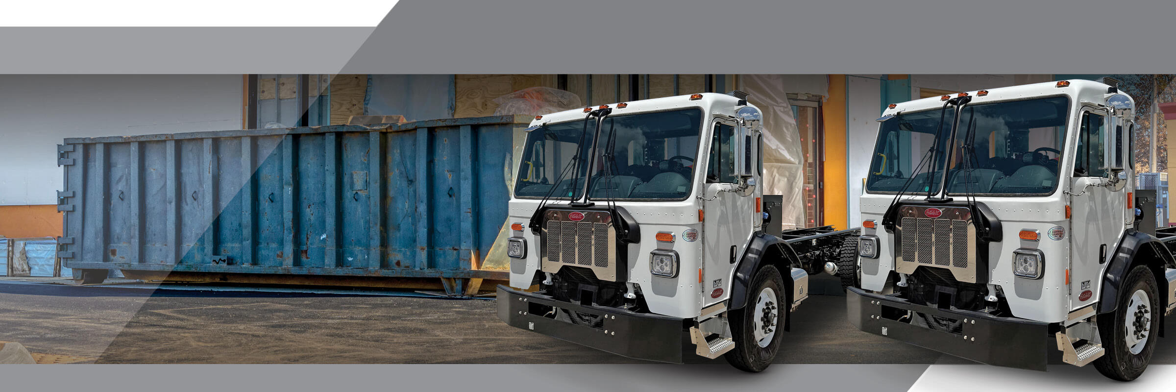 Two Peterbilt Model 520 trucks in front of dumpster