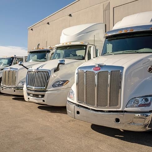 Peterbilt and International trucks lined up outside Rush Truck Center dealership