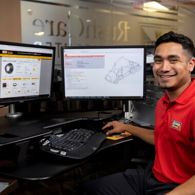 RushCare Rapid Parts employee next to computers