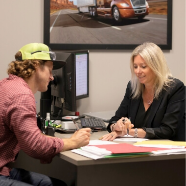 Truck owner signing documents with dealership financing manager