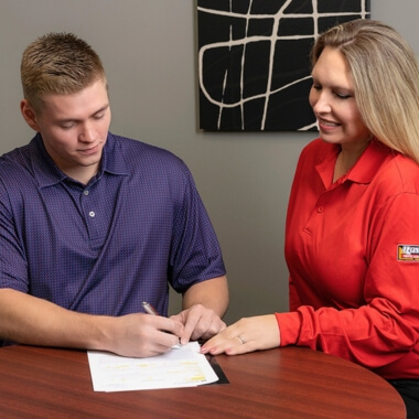 Truck owner signing documents with dealership financing manager