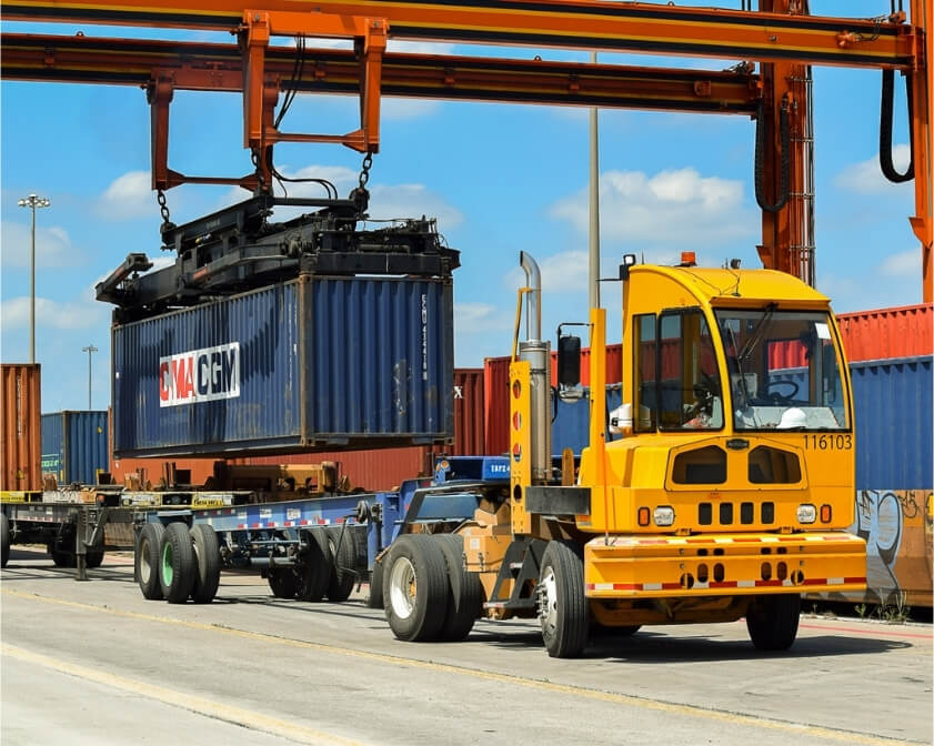 ACTT terminal tractor being loaded with shipping container to transport
