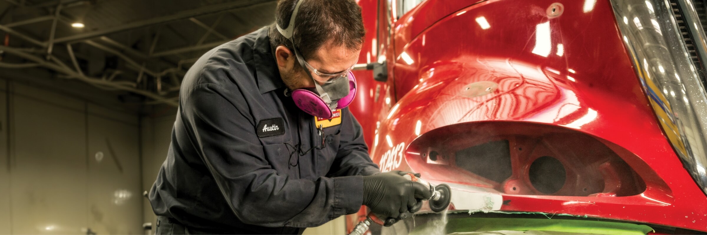 Technician sanding truck body