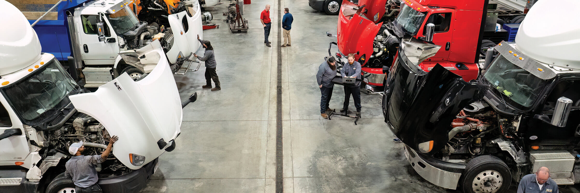 Technicians working on trucks in service bays