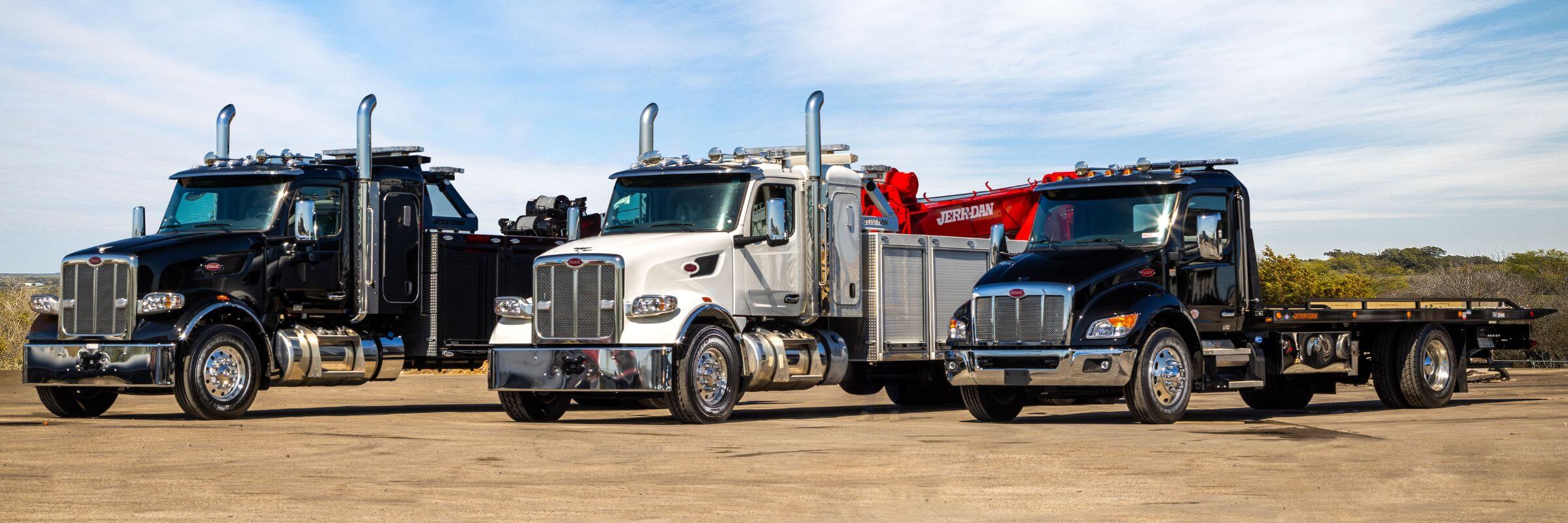 Three Peterbilt trucks with Jerr-Dan tow truck bodies lined up next to each other