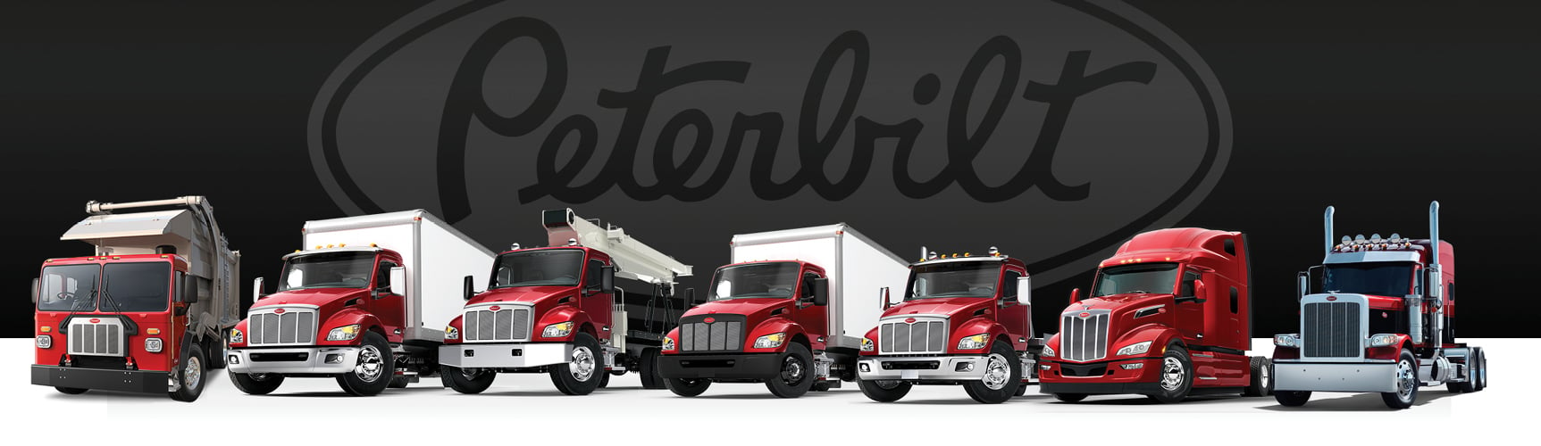 Peterbilt truck lineup with Peterbilt logo behind it | Peterbilt Trucks
